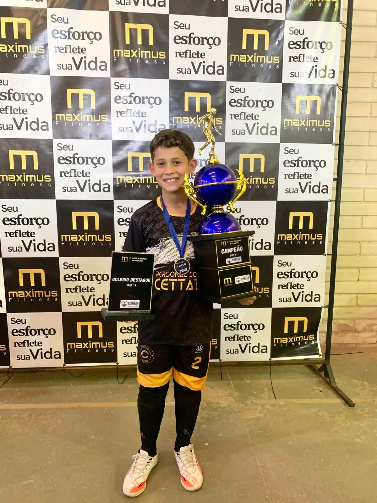 VitinGK com troféu de melhor goleiro da competição e medalha de campeão