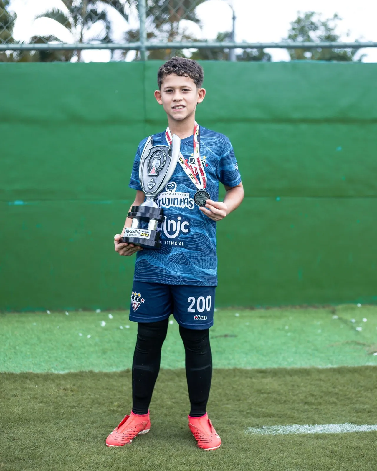 VitinGK segurando troféu e medalha de ouro em campeonato estadual